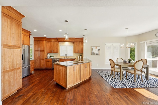 9556 Kemper Dr, Lone Tree, CO 80124 - kitchen with stainless steel appliances, a peninsula, dark wood-style flooring, a chandelier, and recessed lighting