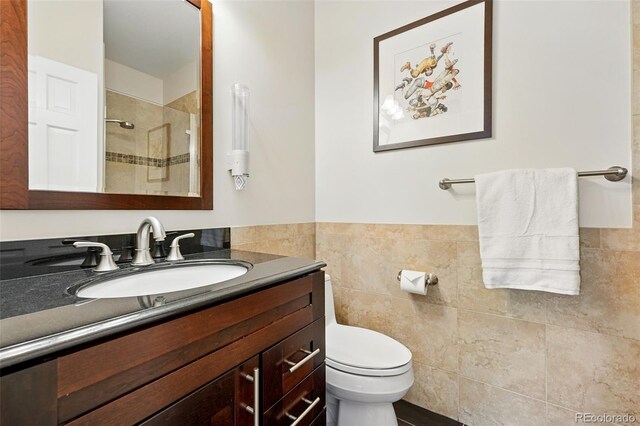 9556 Kemper Dr, Lone Tree, CO 80124 - bathroom featuring vanity, tile walls, a tile shower, and wainscoting