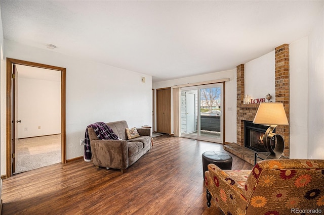 living room featuring wood-type flooring and a brick fireplace