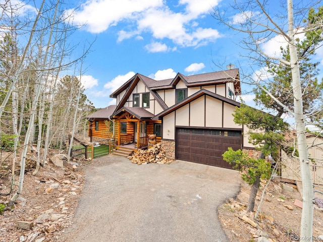 11766 Coal Creek Heights Dr, Golden, CO 80403 - view of front facade with driveway, roof with shingles, stone siding, a garage, and a porch