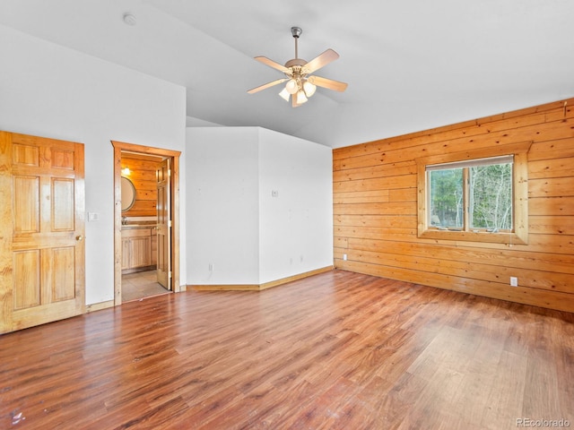 11766 Coal Creek Heights Dr, Golden, CO 80403 - spare room featuring wood finished floors, a ceiling fan, lofted ceiling, wooden walls, and baseboards
