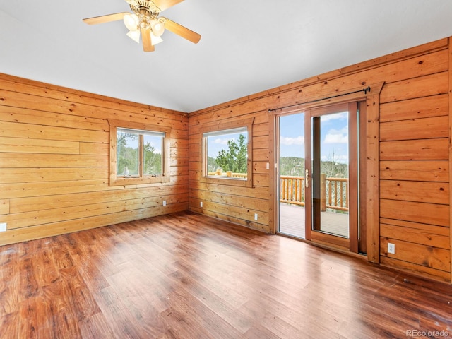 11766 Coal Creek Heights Dr, Golden, CO 80403 - spare room featuring lofted ceiling, healthy amount of natural light, wood finished floors, a ceiling fan, and wood walls