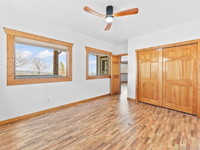 11766 Coal Creek Heights Dr, Golden, CO 80403 - unfurnished bedroom with light wood-style floors, multiple windows, baseboards, and a closet