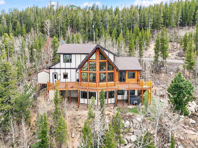 11766 Coal Creek Heights Dr, Golden, CO 80403 - back of house featuring a wooded view, a deck, and a shingled roof