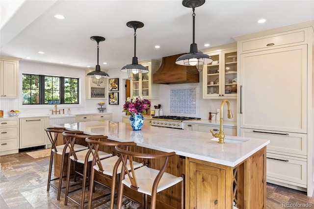 192 Nova Dr, Pine, CO 80470 - kitchen with custom exhaust hood, a center island, glass insert cabinets, light stone countertops, and recessed lighting