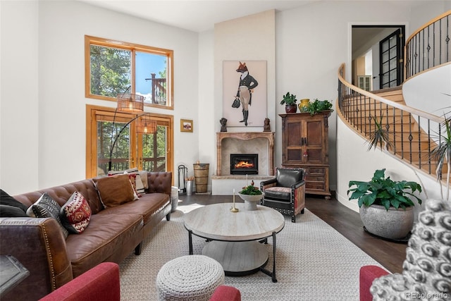 192 Nova Dr, Pine, CO 80470 - living area with stairs, dark wood-style flooring, a fireplace, and a towering ceiling