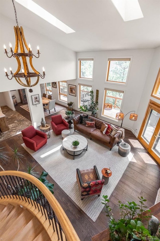 192 Nova Dr, Pine, CO 80470 - living area featuring a skylight, wood-type flooring, a chandelier, and high vaulted ceiling