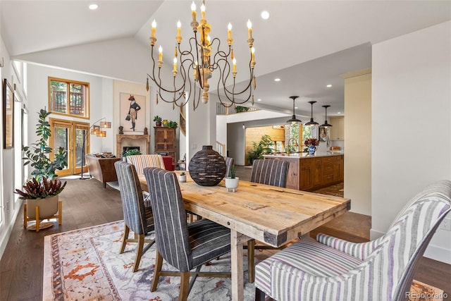 192 Nova Dr, Pine, CO 80470 - dining room with wood-type flooring, a chandelier, vaulted ceiling, recessed lighting, and a fireplace