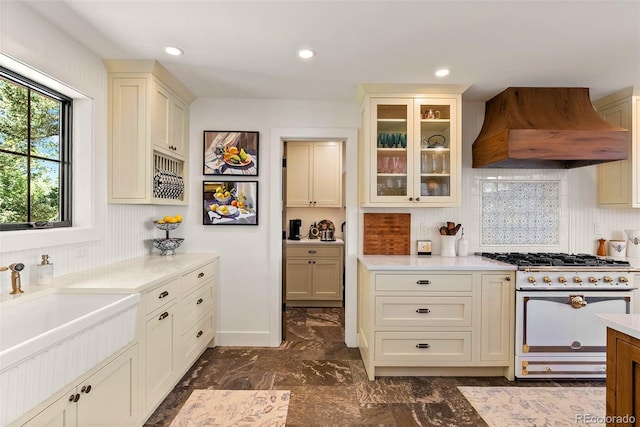 192 Nova Dr, Pine, CO 80470 - kitchen featuring premium range hood, high end white range oven, light countertops, glass insert cabinets, and dark marble finish flooring