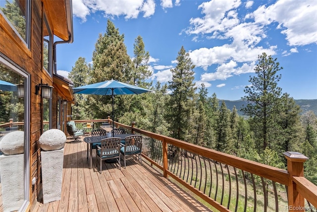 192 Nova Dr, Pine, CO 80470 - wooden deck with outdoor dining area and a view of trees