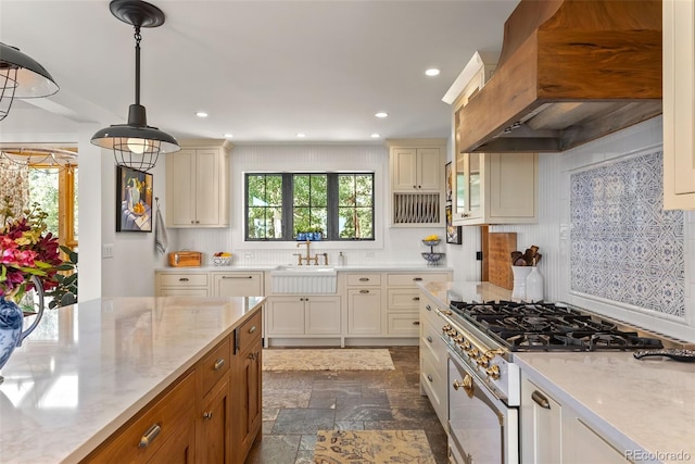 192 Nova Dr, Pine, CO 80470 - kitchen with custom range hood, white range with gas stovetop, dark stone finish floors, light stone counters, and recessed lighting