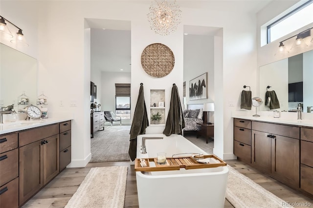 bathroom featuring vanity, hardwood / wood-style floors, a bathtub, and a high ceiling