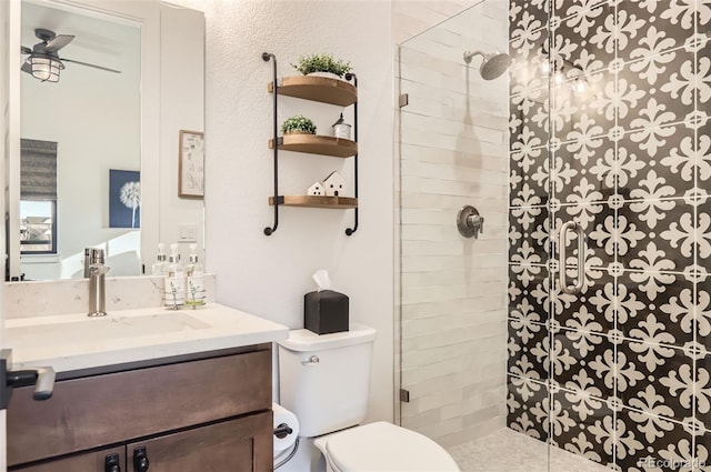 bathroom with a tile shower, vanity, and toilet