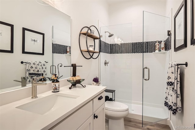 bathroom featuring vanity, toilet, an enclosed shower, and hardwood / wood-style floors