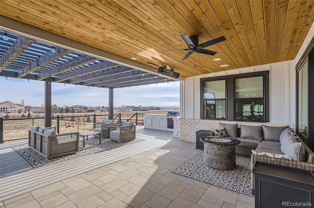 view of patio / terrace featuring an outdoor kitchen, a grill, an outdoor living space with a fire pit, ceiling fan, and a pergola