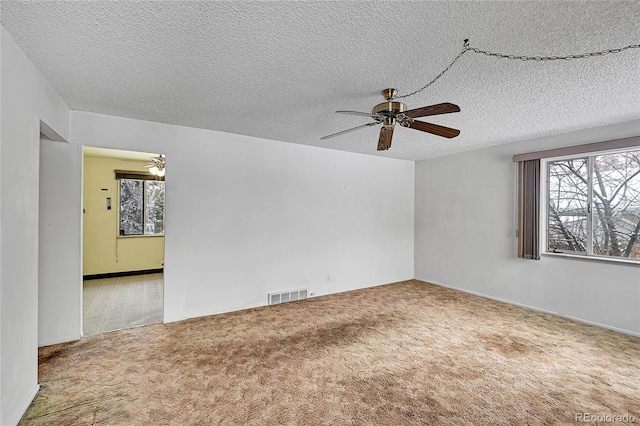 carpeted empty room with ceiling fan and a textured ceiling