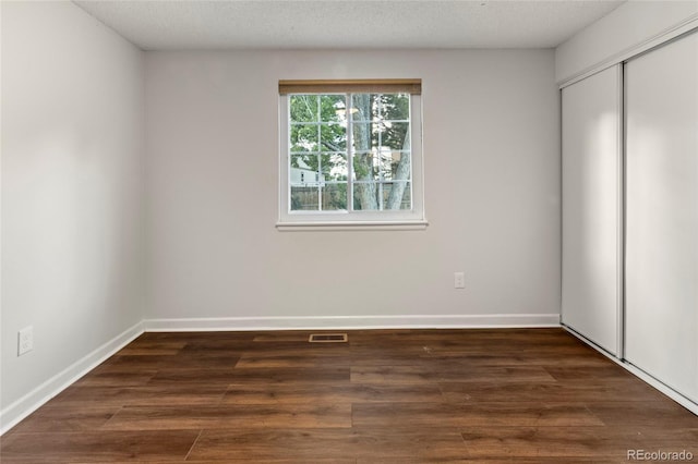 18625 E Kent Dr, Aurora, CO 80013 - unfurnished bedroom featuring a closet, dark wood finished floors, and a textured ceiling