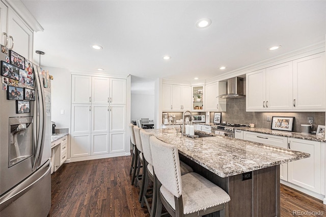 5265 S Cathay Way, Centennial, CO 80015 - kitchen with appliances with stainless steel finishes, wall chimney exhaust hood, dark wood-style floors, white cabinetry, and decorative backsplash