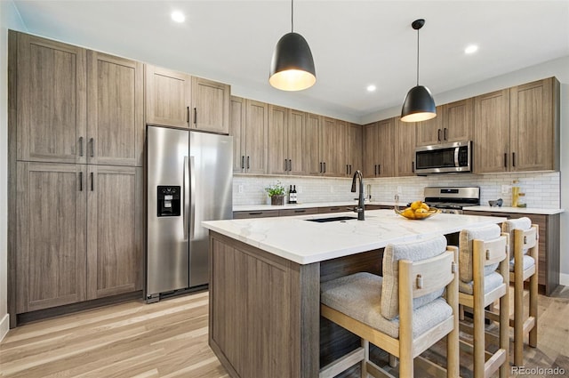 4127 Tejon St, Denver, CO 80211 - kitchen featuring appliances with stainless steel finishes, a sink, backsplash, light wood-style flooring, and recessed lighting