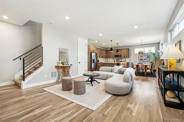 4127 Tejon St, Denver, CO 80211 - living area featuring light wood-style flooring, recessed lighting, stairway, and baseboards