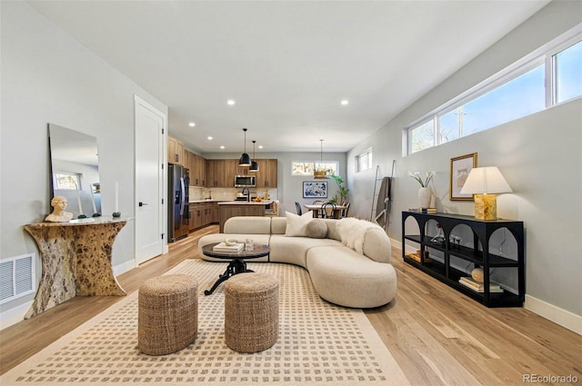 4127 Tejon St, Denver, CO 80211 - living area with light wood finished floors, recessed lighting, baseboards, and a chandelier