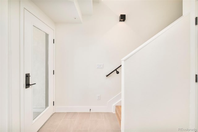 stairway with baseboards and tile patterned flooring