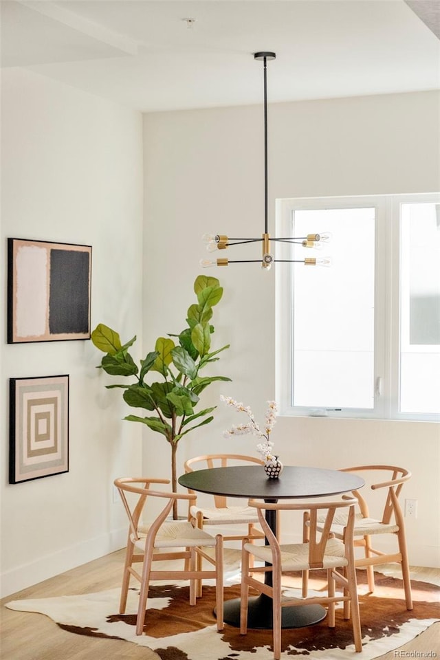 dining area with baseboards and wood finished floors