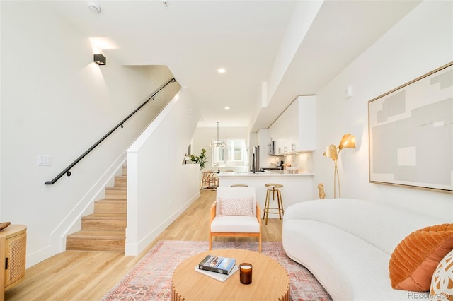 living area with visible vents, light wood-style floors, baseboards, stairway, and recessed lighting