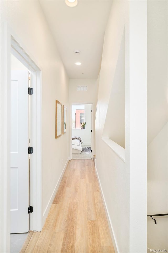 corridor featuring recessed lighting, baseboards, visible vents, and light wood-type flooring