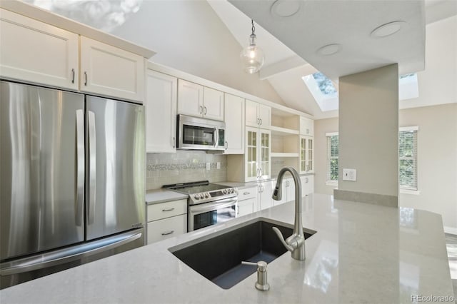 9455 W 81st Ave Unit A, Arvada, CO 80005 - kitchen with stainless steel appliances, a sink, vaulted ceiling, tasteful backsplash, and a skylight