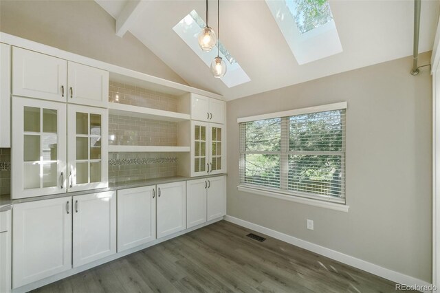 9455 W 81st Ave Unit A, Arvada, CO 80005 - unfurnished dining area with a skylight, dark wood-style flooring, and baseboards