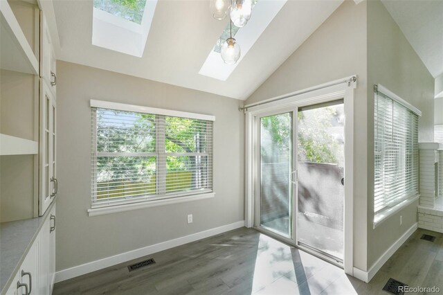 9455 W 81st Ave Unit A, Arvada, CO 80005 - unfurnished dining area with a skylight, vaulted ceiling, wood finished floors, and baseboards