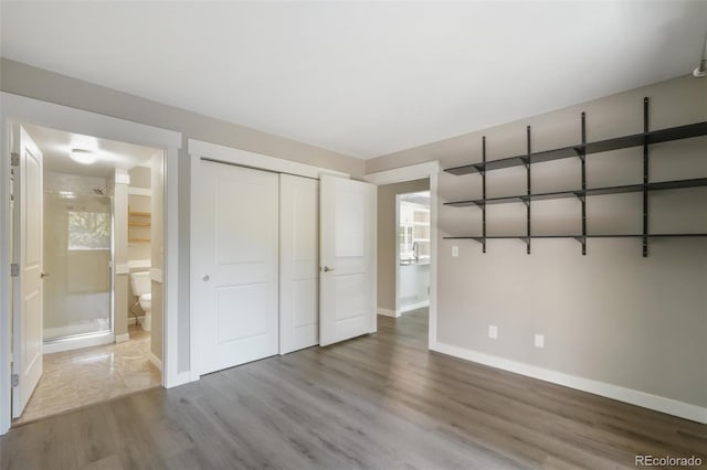 9455 W 81st Ave Unit A, Arvada, CO 80005 - unfurnished bedroom with baseboards, wood finished floors, a closet, and connected bathroom