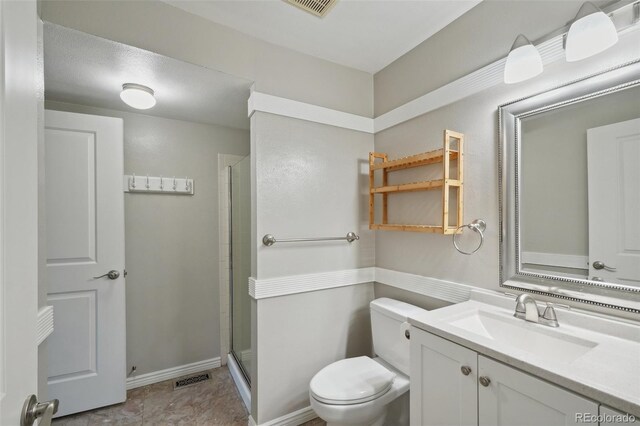 9455 W 81st Ave Unit A, Arvada, CO 80005 - bathroom featuring toilet, vanity, a stall shower, and baseboards