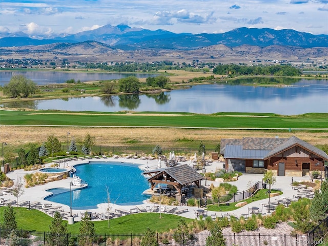 community pool with a gazebo, a community hot tub, fence, and a water and mountain view