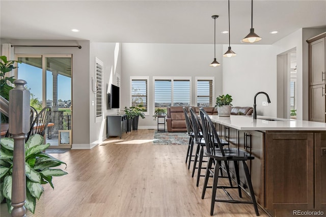 kitchen with light countertops, a wealth of natural light, a sink, and light wood-style flooring