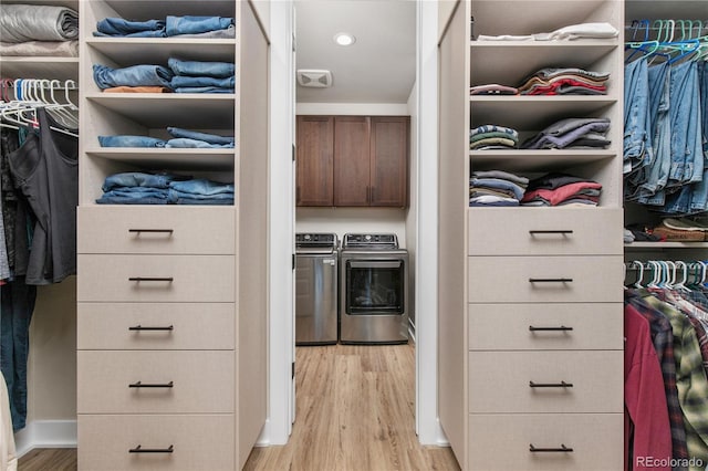 walk in closet with independent washer and dryer and light wood-style flooring