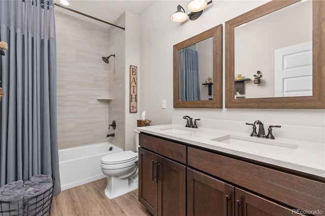 bathroom with shower / bath combo with shower curtain, a sink, toilet, and wood finished floors