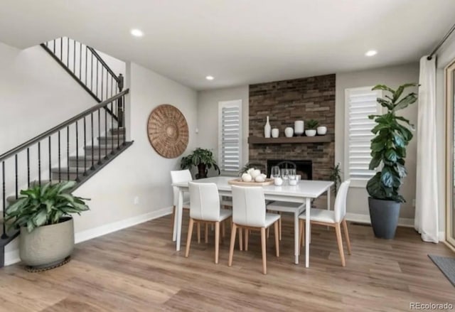 dining area featuring stairs, baseboards, wood finished floors, and recessed lighting