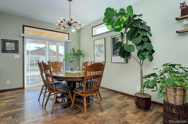 dining area with dark hardwood / wood-style flooring and an inviting chandelier