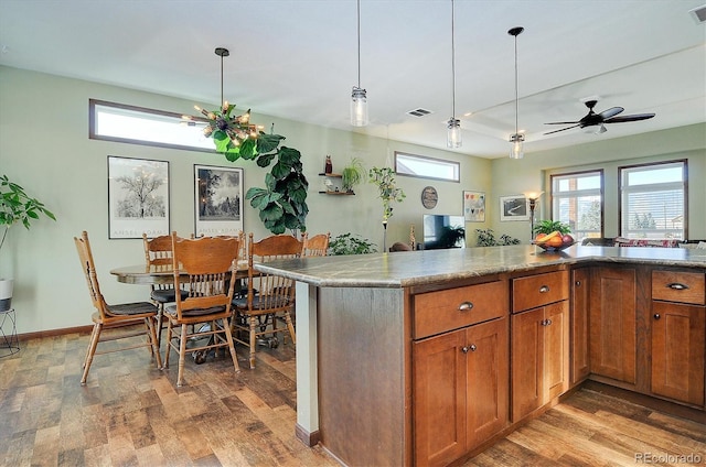 kitchen with ceiling fan, light hardwood / wood-style flooring, and hanging light fixtures