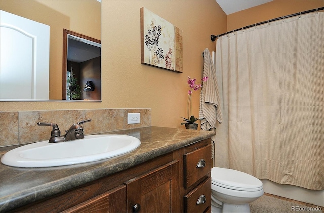 bathroom with vanity, tasteful backsplash, and toilet