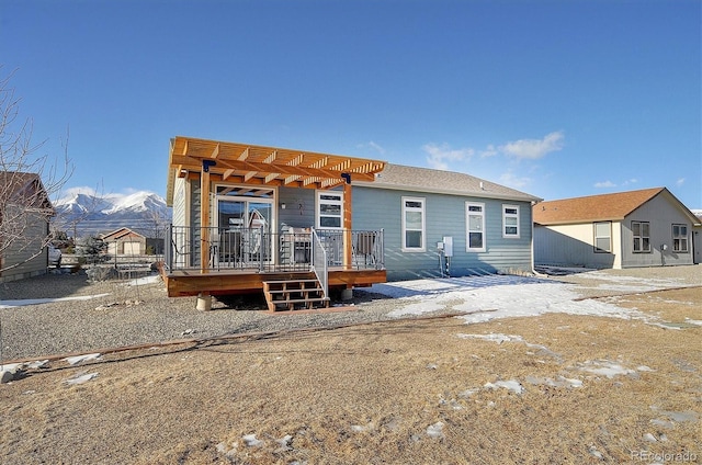 rear view of house featuring a deck with mountain view and a pergola