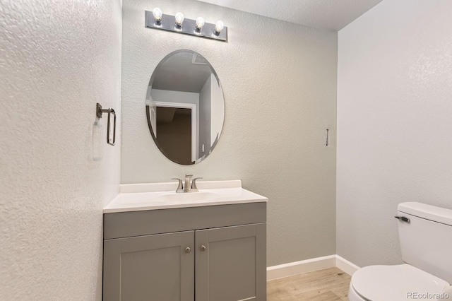 6108 S Harvest Ct, Aurora, CO 80016 - bathroom featuring vanity, toilet, wood finished floors, and baseboards