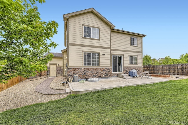 6108 S Harvest Ct, Aurora, CO 80016 - rear view of property featuring a patio, stone siding, and entry steps
