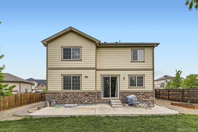 6108 S Harvest Ct, Aurora, CO 80016 - back of house with a patio area, entry steps, stone siding, and a fenced backyard