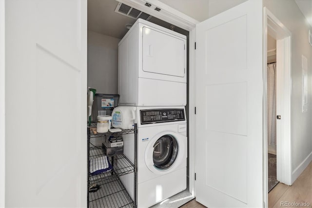 clothes washing area featuring stacked washer / drying machine