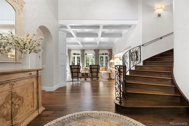 entryway with dark wood-type flooring, baseboards, beamed ceiling, stairway, and coffered ceiling