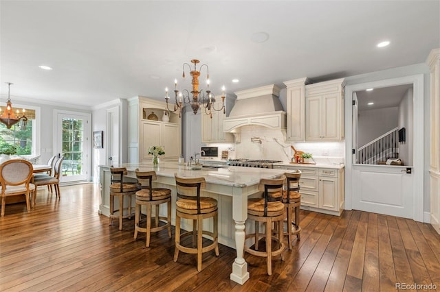 kitchen with decorative backsplash, custom exhaust hood, dark wood-style floors, and a chandelier