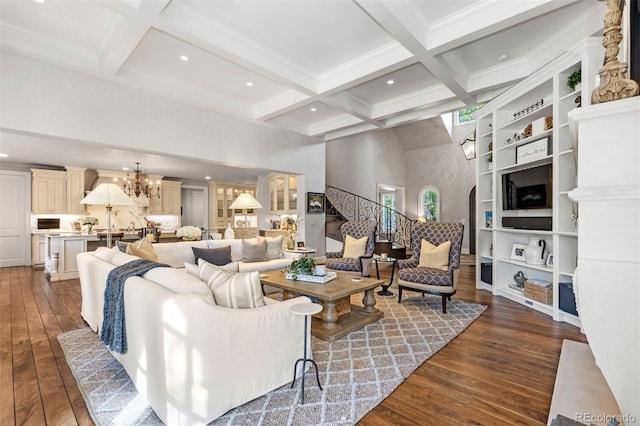 living room with dark wood-style floors, a chandelier, beamed ceiling, and coffered ceiling